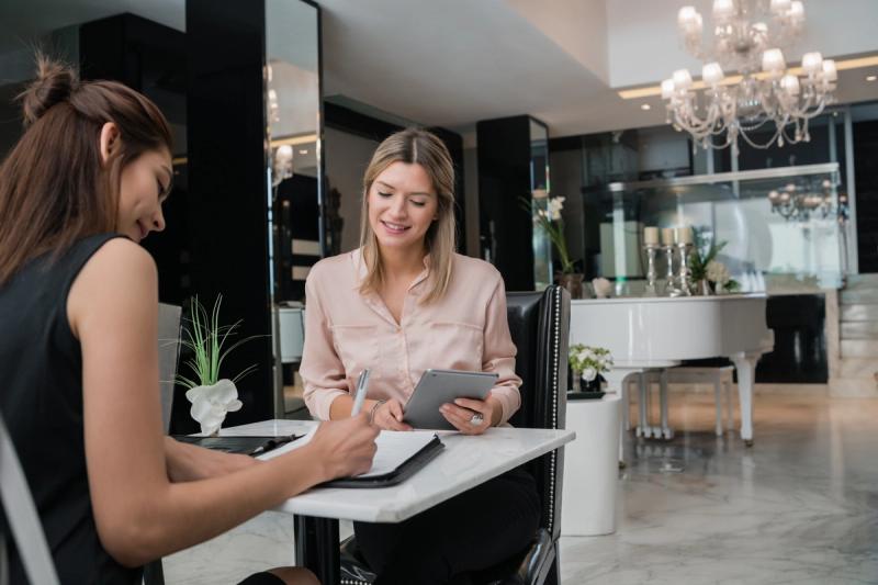 blond client at beauty salon reception reading salon policies for appointments and cancellations