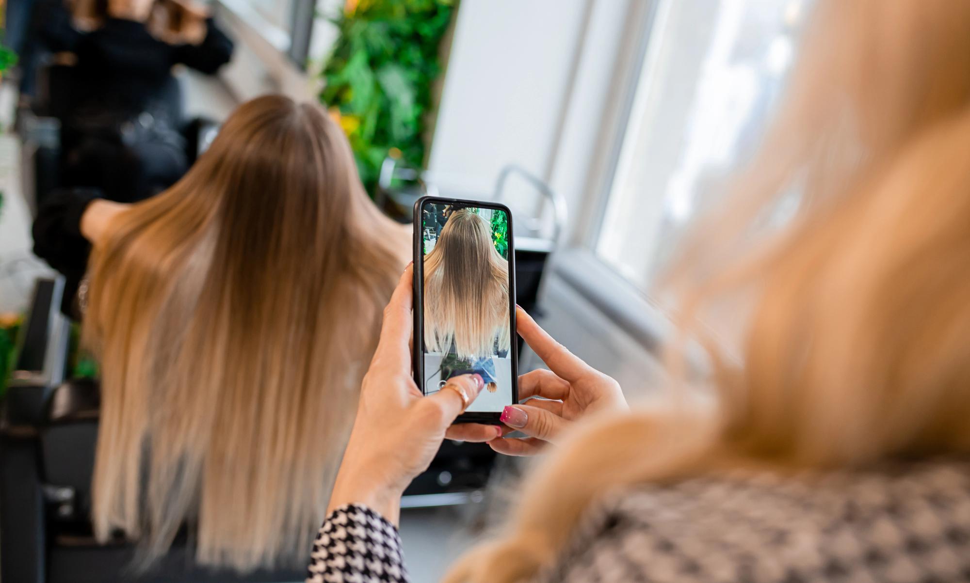 hairdresser taking photos of client hair to make salon business growth