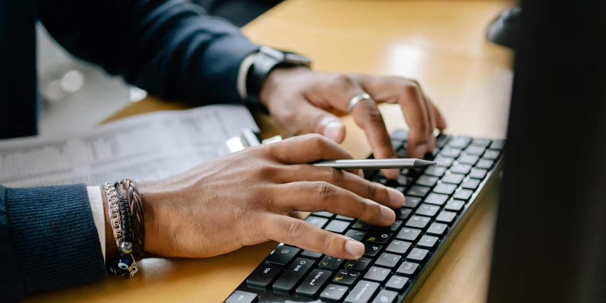 Person typing on a computer while using a school administration software and student management platform
