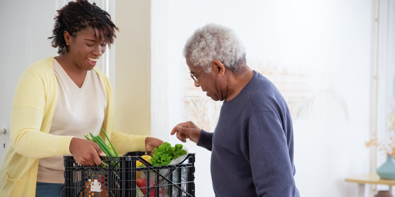 elderly man picking up vegetables ordered with best non-medical home care software