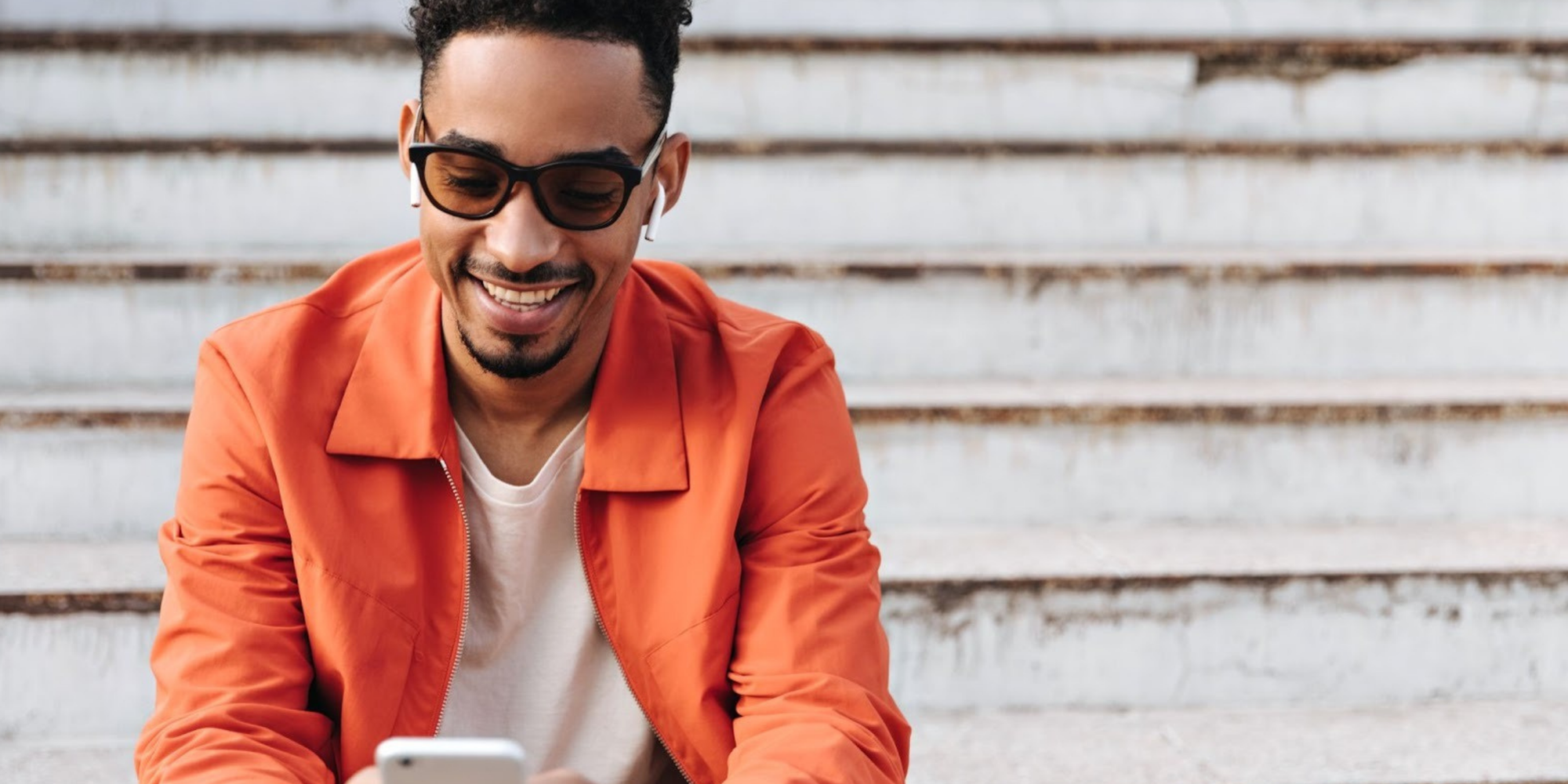  Man in a collared orange shirt with sunglasses replying to a Google Calendar appointment text reminder