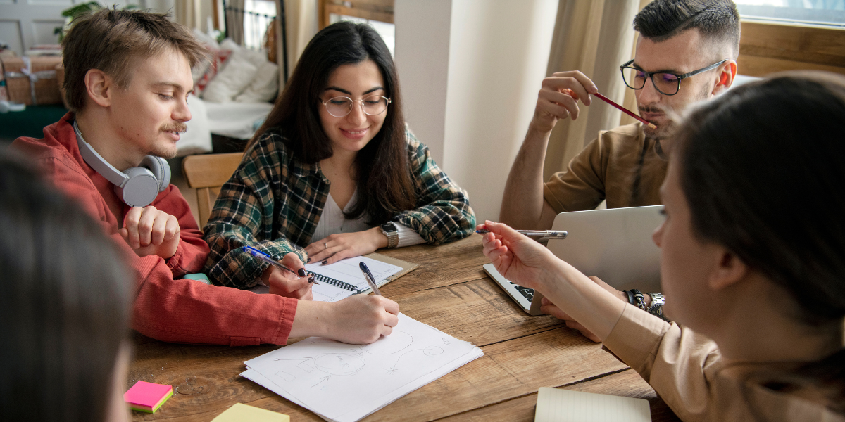 teenagers by wooden table during classroom group projects