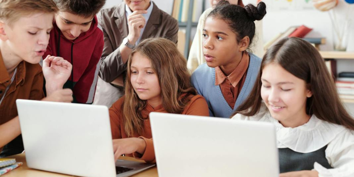 elementary school kids by laptops trying collaborative learning tools